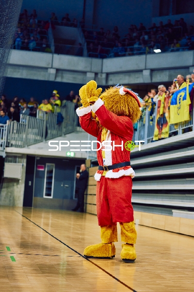 Maskottchen in Weihnachtskostüm begrüßt die Zuschauer.