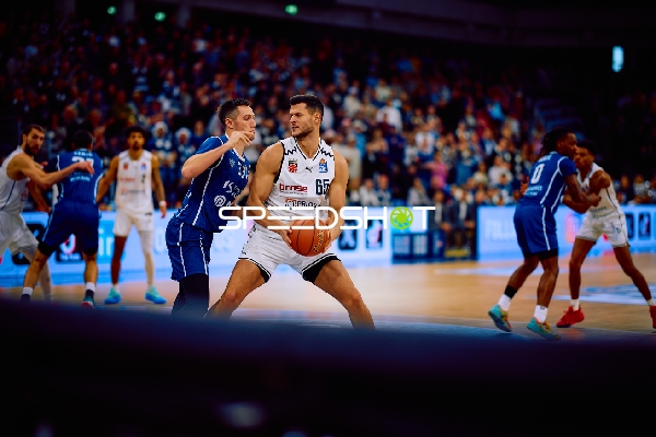 Filip Stanic von Brose Bamberg dribbelt den Ball aggressiv, während er von einem Verteidiger der MLP Academics Heidelberg bedrängt wird.