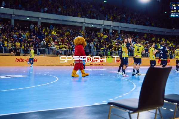 Spieler von Rhein Neckar Löwen feiern auf dem Spielfeld.