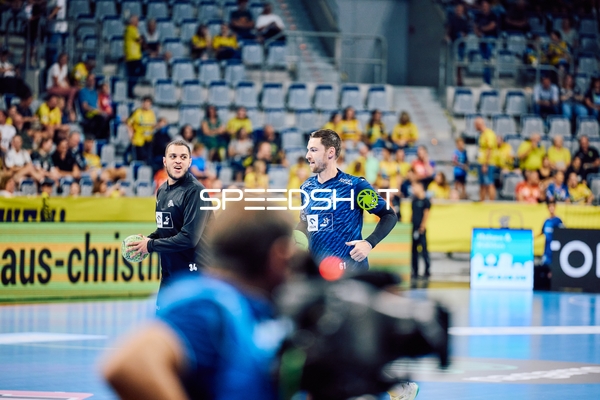 Zwei Spieler von THW Kiel diskutieren auf dem Spielfeld.