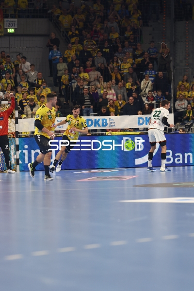 Rhein Neckar Löwen Spieler in gelben Trikots laufen aufs Tor zu, während HSG Wetzlar Spieler in weißem Trikot verteidigt.