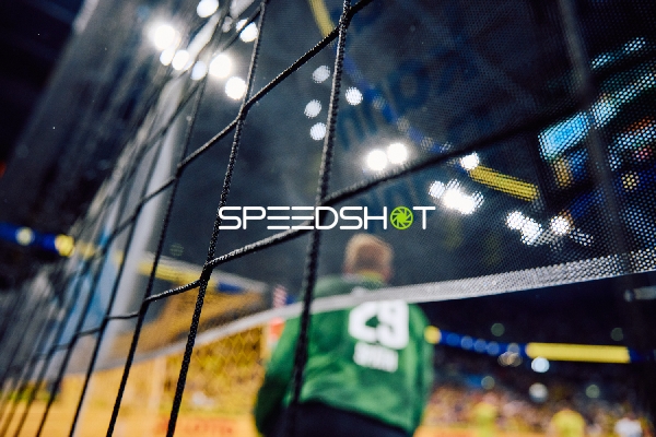 Ein Torwart steht im Fokus hinter einem Netz.