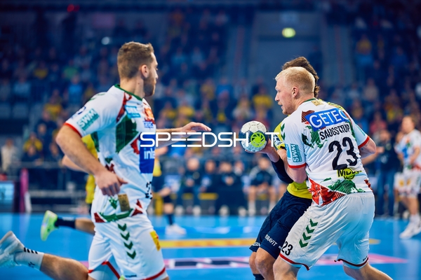 Ein Spieler von SC Magdeburg mit der Nummer 23 führt den Ball gegen die Verteidigung der Rhein Neckar Löwen.