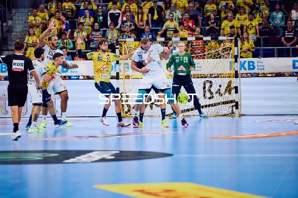 Ein Spieler von Rhein Neckar Löwen greift zum Tor an, während MT Melsungen in der Verteidigung steht.