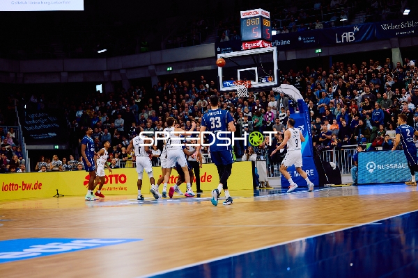 Ein Spieler von MLP Academics Heidelberg versucht, den Ball zum Korb zu bringen, während ein Spieler von Brose Bamberg verteidigt.