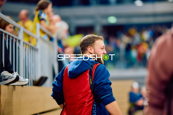 Eine Person steht am Spielfeldrand und beobachtet das Geschehen.