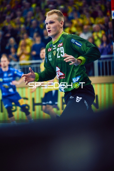 Ein Spieler in grünem Trikot von Rhein Neckar Löwen steht bereit für eine Aktion.