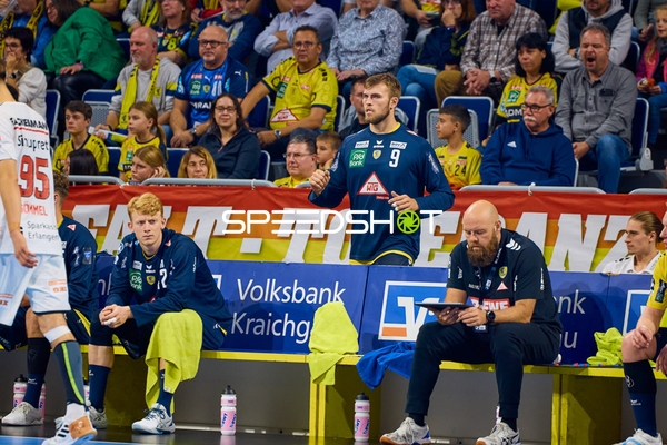 Spieler von Rhein Neckar Löwen beobachten das Spiel von der Bank aus.