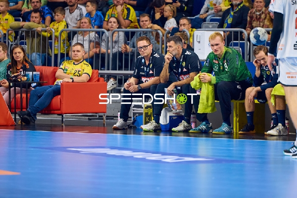 Spieler und Trainer der Rhein Neckar Löwen sitzen auf der Bank während des Spiels.