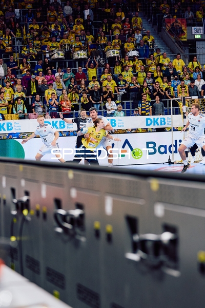 Ein Spieler der Rhein Neckar Löwen versucht, den Ball an Spielern von HSV Hamburg vorbeizuspielen.