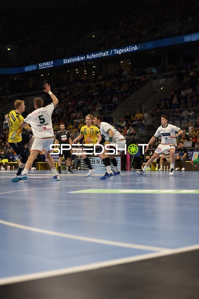 Ein Spieler von Rhein Neckar Löwen passt den Ball, während die Verteidiger von HSG Wetzlar versuchen zu blocken.