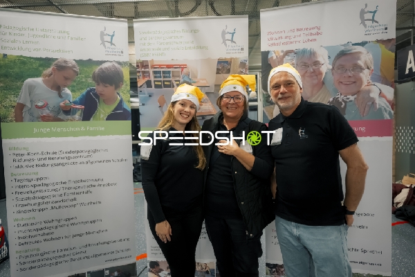 Drei Personen vor Infostand