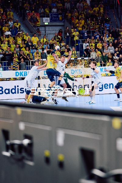 Ein Spieler der Rhein Neckar Löwen versucht, ein Tor zu werfen, während Spieler des HSV Hamburg verteidigen.