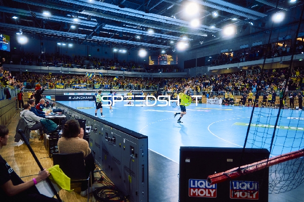 Ein Handballspiel wird in einer Halle gespielt.