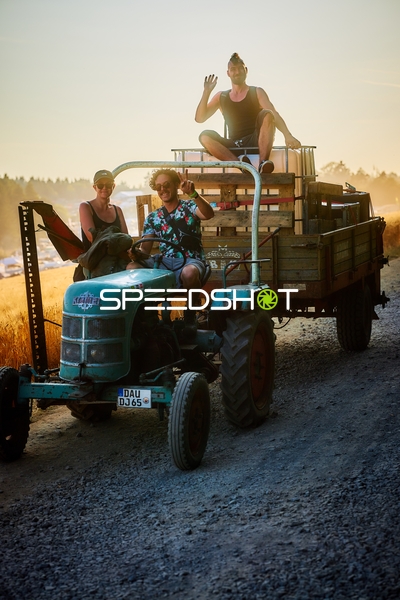 Traktor auf Feldweg bei Sonnenuntergang