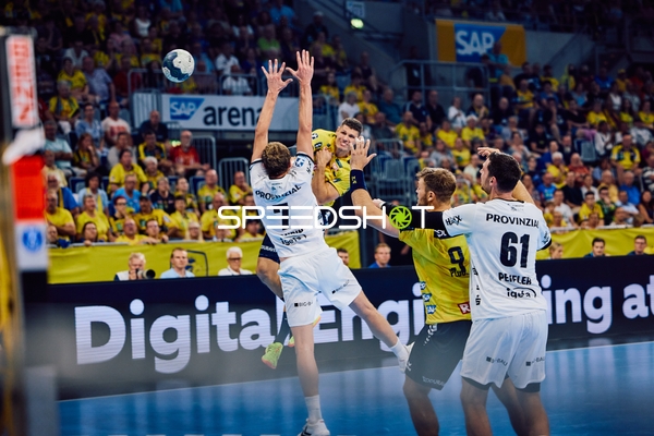 Ein Spieler der Rhein Neckar Löwen versucht, den Ball über die Verteidigung von THW Kiel zu werfen.