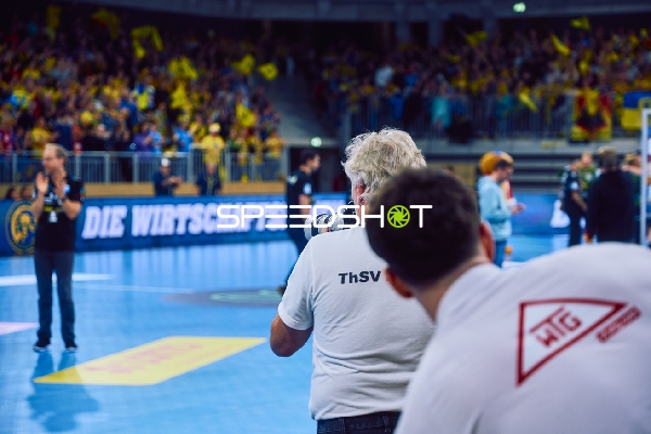 Ein Fotograf auf dem Spielfeld macht Bilder vom Spiel.