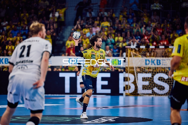 Ein Spieler der Rhein Neckar Löwen ist im Angriff und hält den Ball bereit zum Wurf.
