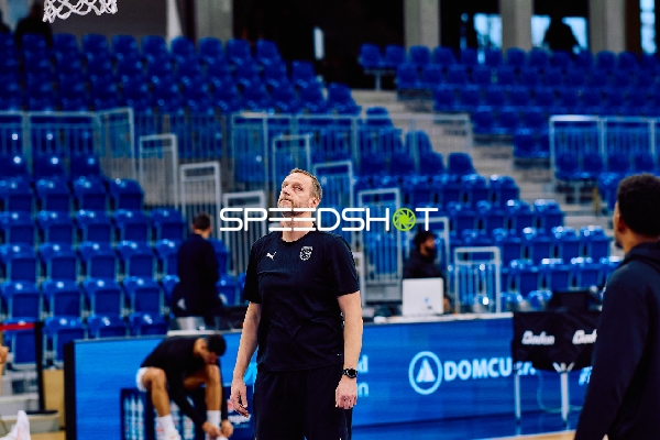 Ein Trainer oder Offizieller steht nachdenklich auf dem Spielfeld.