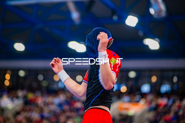 Ein Spieler in rotem Trikot zieht Trikot über Kopf