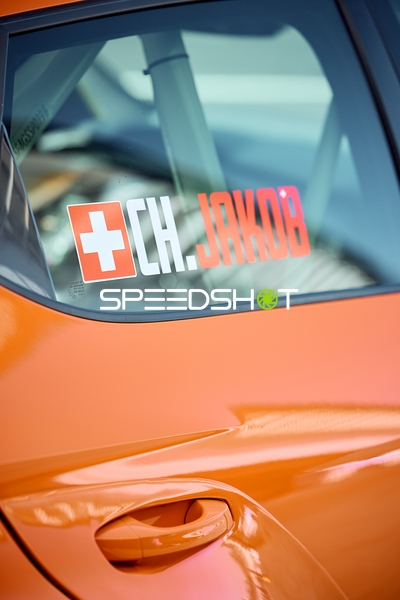 Orangefarbener Sportwagen mit 'CH.JAKOB' Schriftzug