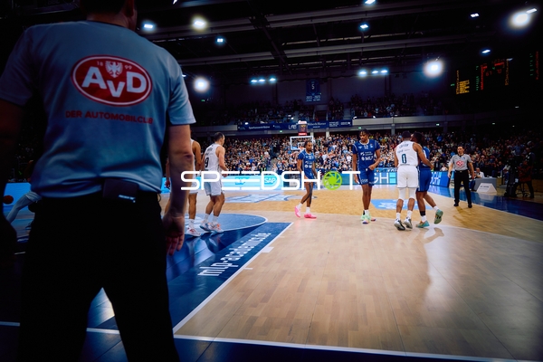 Ein Basketballspiel im Gange mit Spielern auf dem Spielfeld.