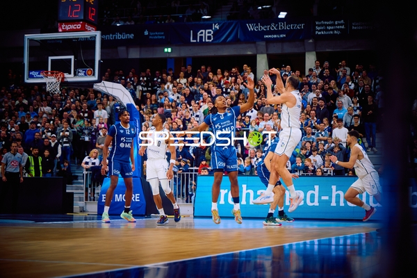 Ein Spieler von Brose Bamberg versucht einen Sprungwurf, während die MLP Academics Heidelberg verteidigen.