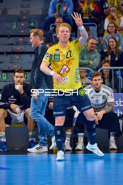 Ein Spieler von Rhein Neckar Löwen mit der Nummer 22 gibt ein Handzeichen auf dem Spielfeld.