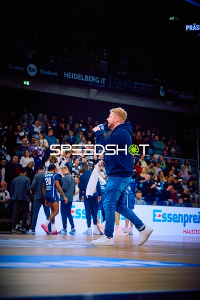 Ein Mannschaftsmitglied verkündet etwas über ein Mikrofon während des Spiels.