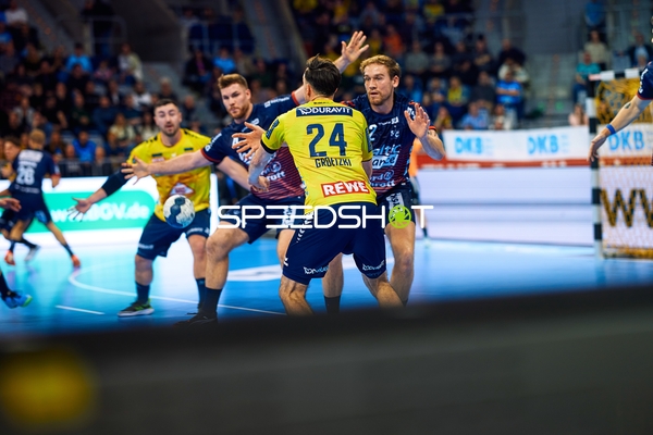 Ein Spieler von Rhein Neckar Löwen setzt zu einem Wurf an, während mehrere Abwehrspieler von SG Flensburg Handewitt versuchen zu blocken.