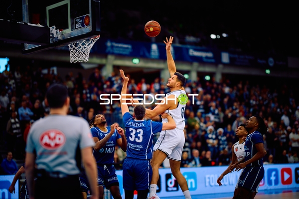 Ein Spieler versucht einen Wurf am Korb während eines Basketballspiels.