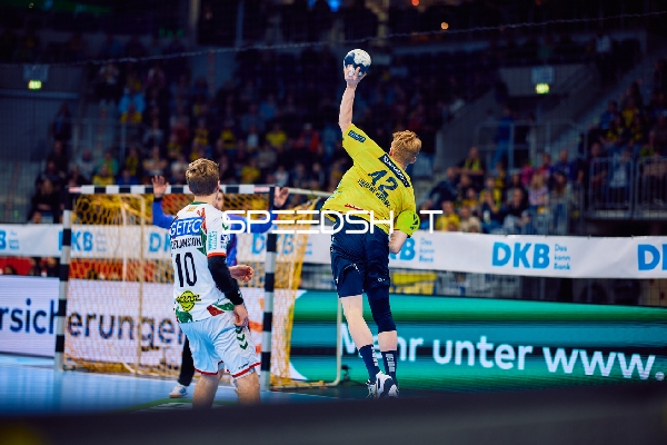 Ein Spieler von Rhein Neckar Löwen springt in die Luft und hält den Ball.