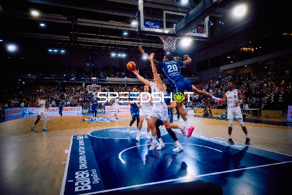 Ein Spieler von Brose Bamberg versucht, den Ball zu blocken, während ein Spieler von MLP Academics Heidelberg zum Korb zieht.