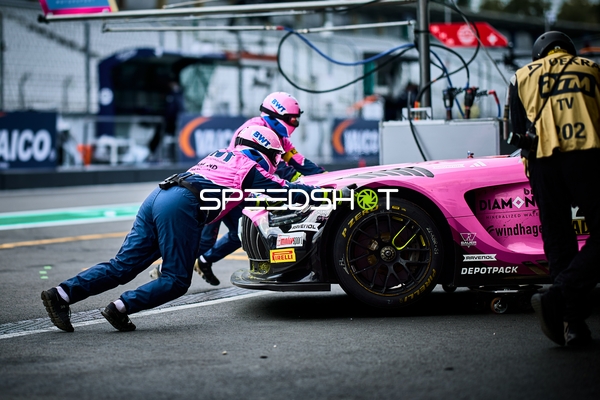 Mechaniker schieben Fahrzeug in der Boxengasse