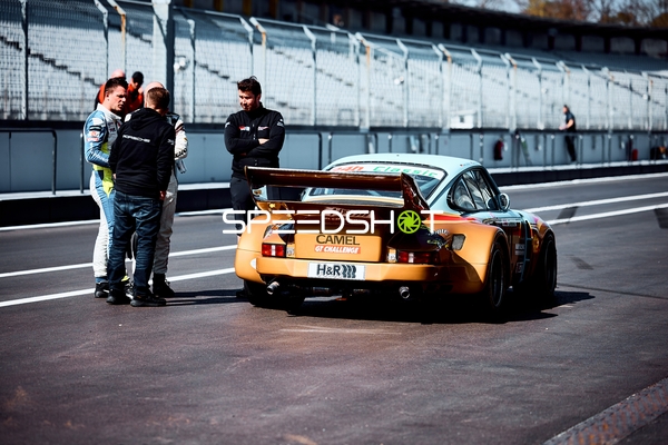 Gespräch in der Boxengasse neben einem Porsche