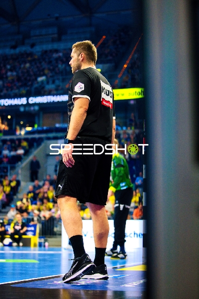 Ein Trainer oder Offizieller steht am Spielfeldrand.