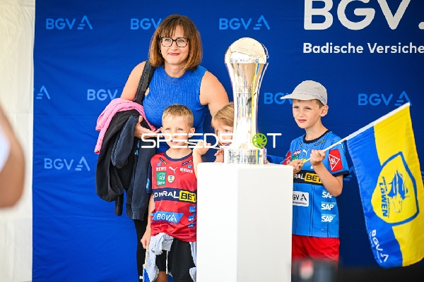 Fans posieren mit einem Pokal und halten Fahnen der Rhein Neckar Löwen.