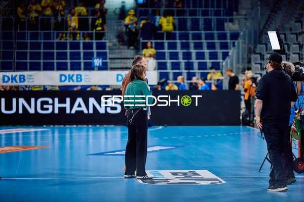 Interviewer führt ein Interview auf dem Spielfeld.