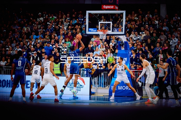 Ein Spieler von Brose Bamberg mit der Nummer 12 wirft den Ball in Richtung Korb.