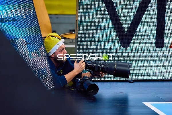 Ein Fotograf liegt am Spielfeldrand und macht Fotos.