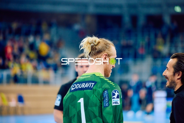 Spieler in grünem Trikot unterhält sich mit einer anderen Person.