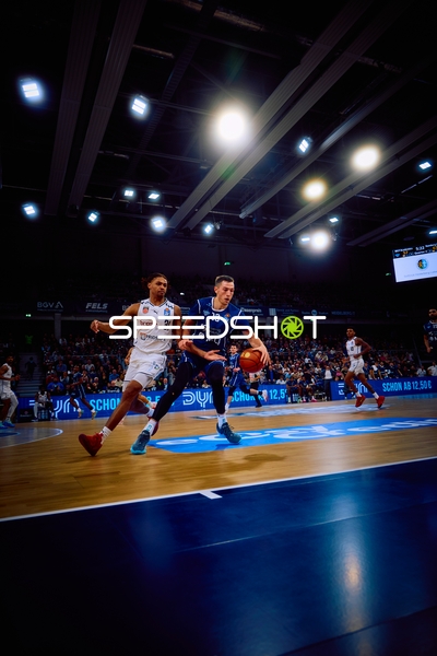 Ein Spieler von MLP Academics Heidelberg dribbelt den Ball, während ein Spieler von Brose Bamberg verteidigt.