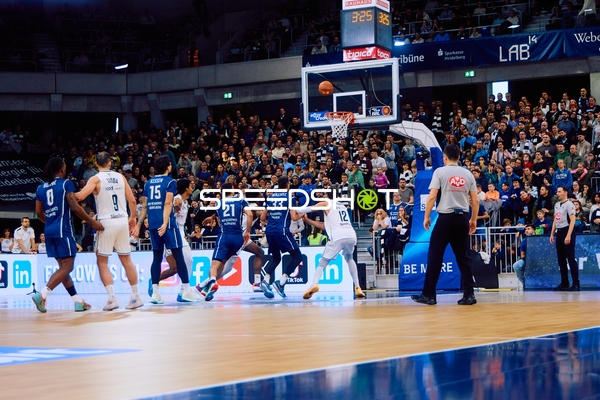 Ein Spieler von MLP Academics Heidelberg versucht einen Korb zu werfen, während Spieler von Brose Bamberg verteidigen.