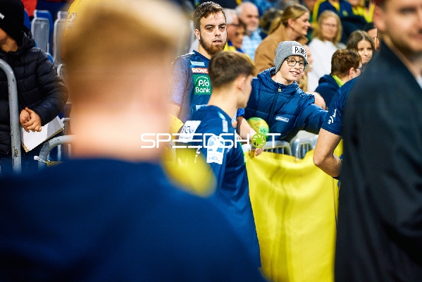 Spieler von SG Flensburg Handewitt interagieren mit den Fans am Spielfeldrand.