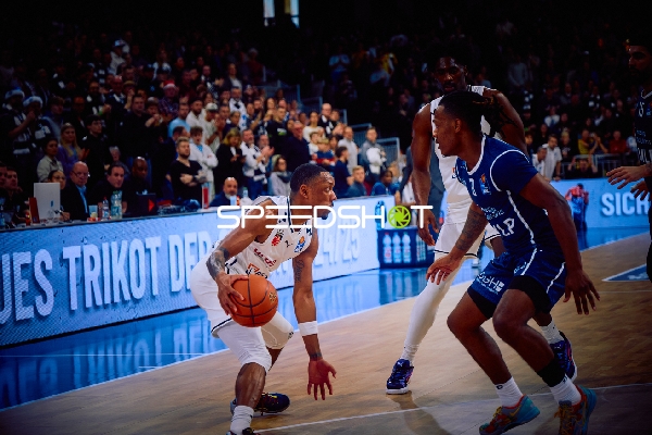 Ein Spieler der MLP Academics Heidelberg dribbelt den Ball, während ein Spieler von Brose Bamberg verteidigt.