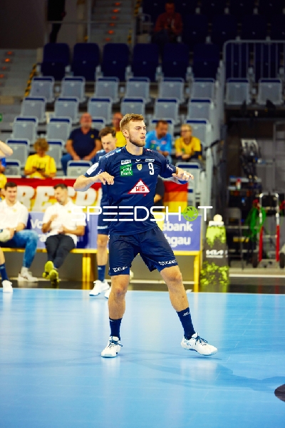 Spieler in Aktion während eines Handballspiels.