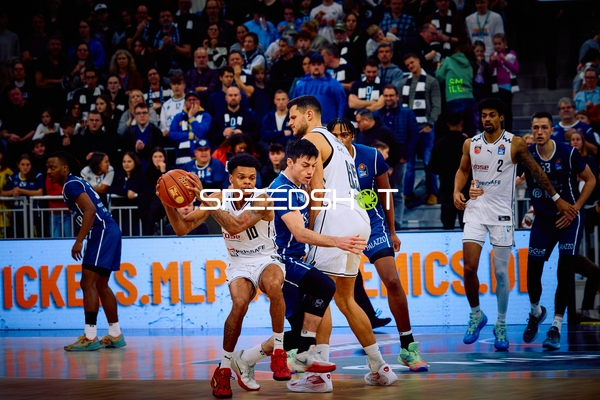 Ein Spieler von Brose Bamberg hält den Ball, während ein Spieler von MLP Academics Heidelberg verteidigt.