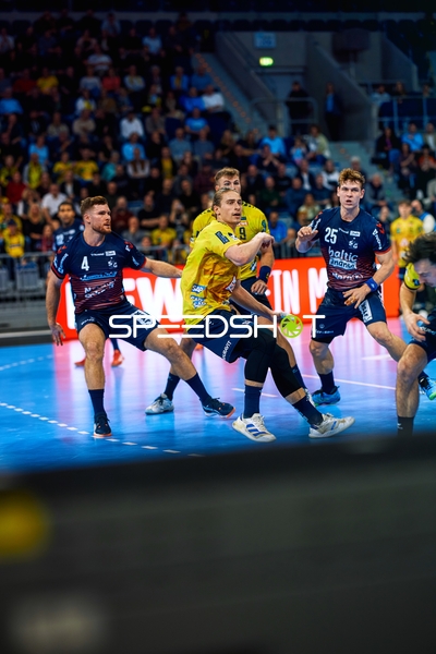 Ein Spieler von Rhein Neckar Löwen schießt auf das Tor, während Spieler von SG Flensburg Handewitt verteidigen.