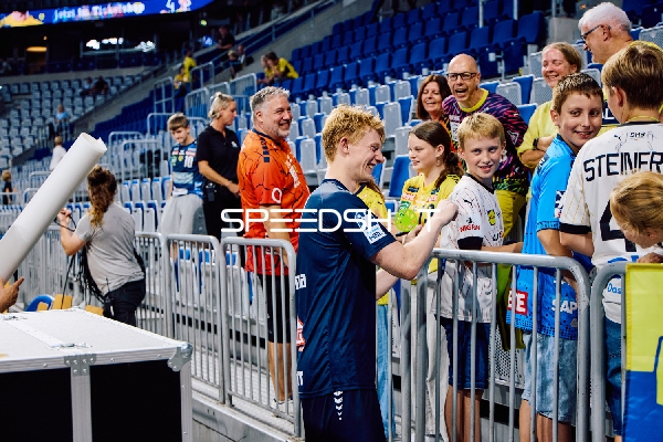Ein Spieler von THW Kiel gibt Autogramme an Fans.