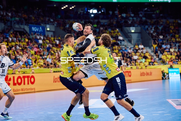 Ein Spieler von THW Kiel versucht, den Ball gegen zwei Spieler der Rhein Neckar Löwen zu werfen.